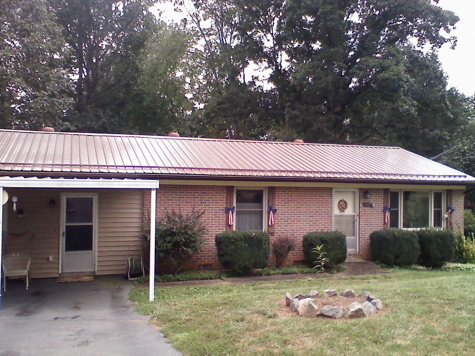 Bronze metal roof and carport on a brick ranch home — Roof Repair work by our crew in Parrish